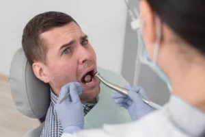 a man is at the dentist and is in pain. hydrogen alkaline water can help you with your teeth